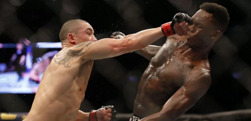 Robert Whittaker como Israel Adesanya